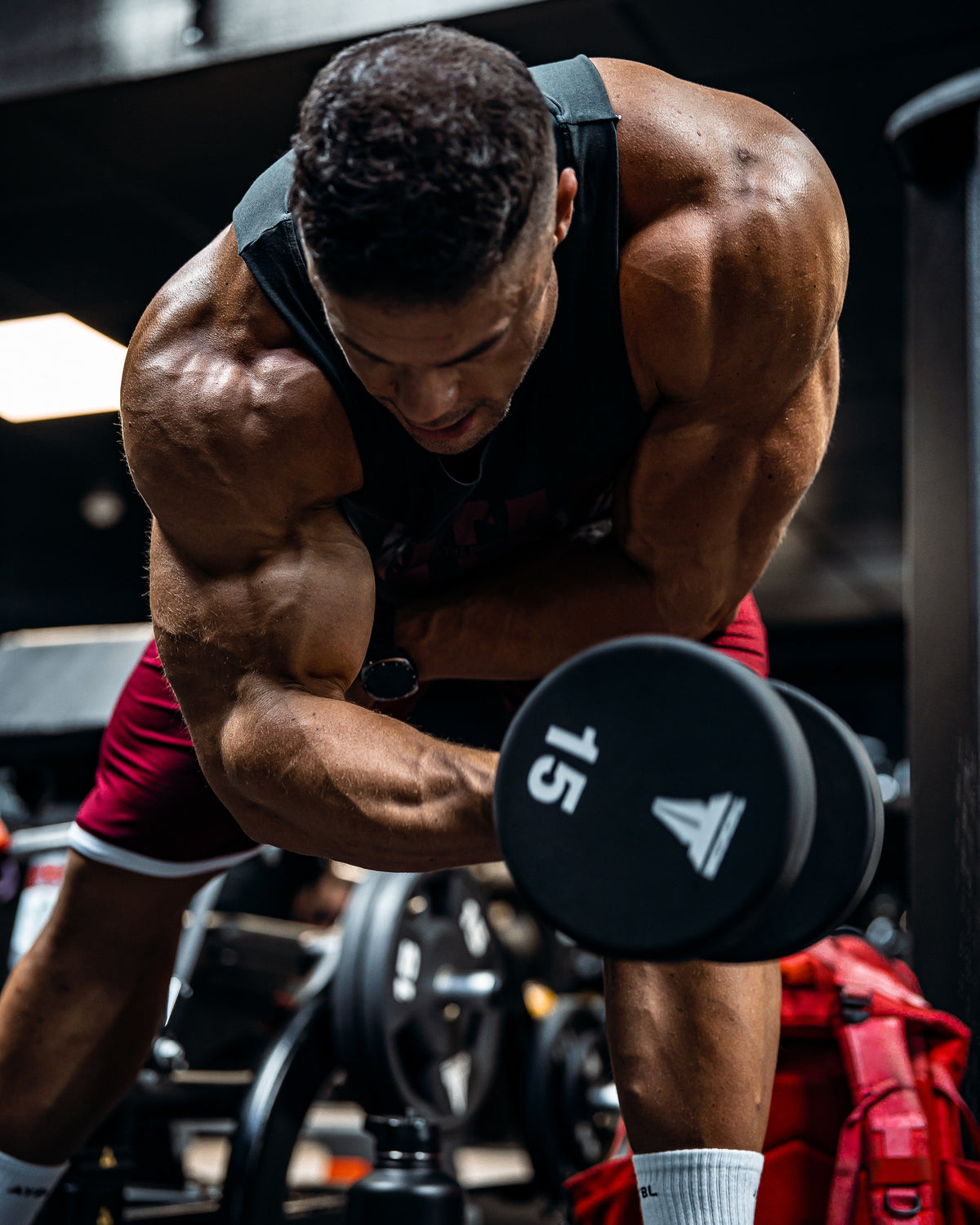 Wesley Vissers training with a dumbbell in a dark gym, arms and shoulders under load - Custom Classic Workout Plan